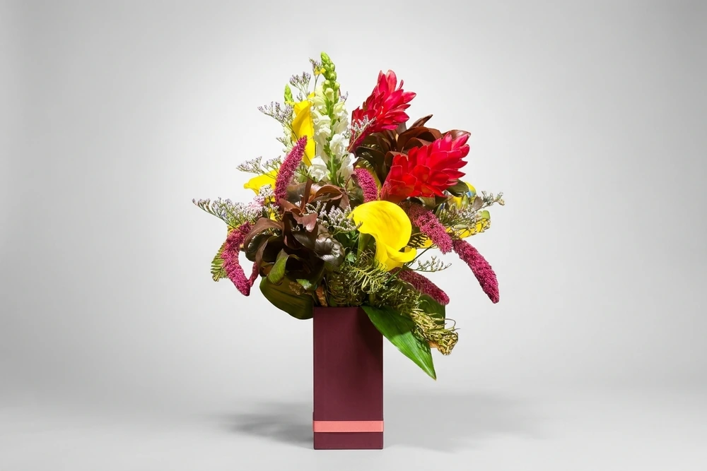 Arranjo Floral Tropical com Callas Amarelas e Alpínias no Vaso de Vidro Retangular